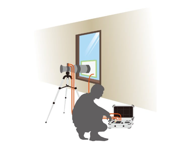 気密測定する人と気密測定機