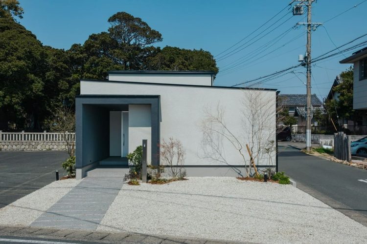 青空の下に建つ白い外壁と黒い縁取りがシンプルな平屋のモダンな住宅