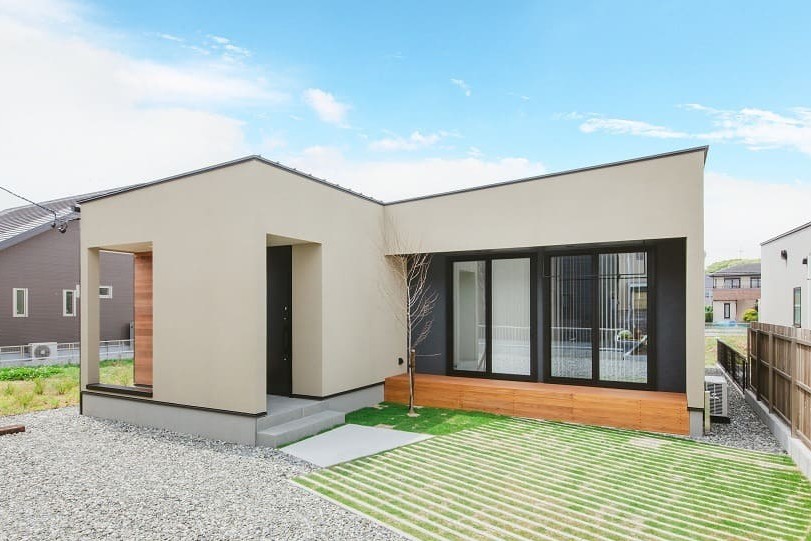 ベージュの外壁とウッドデッキがある住宅の外観